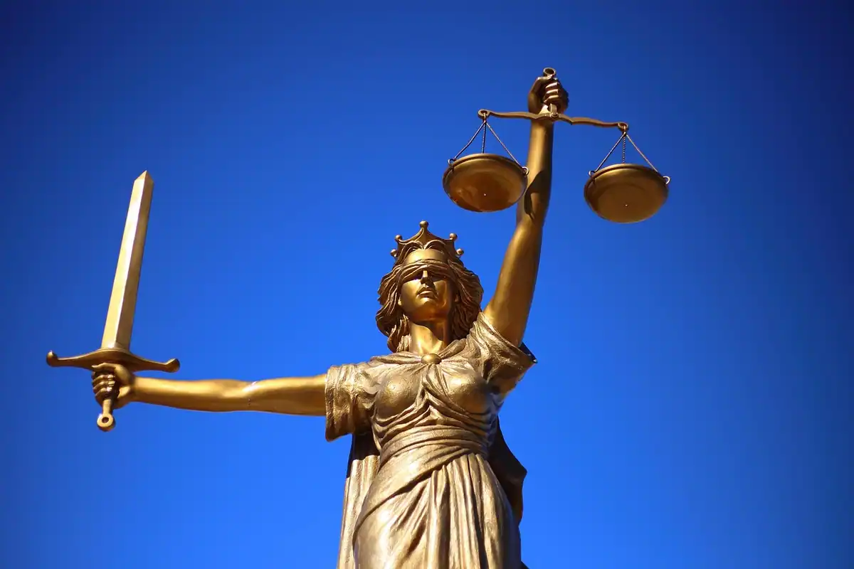 Statuie a zeiței justiției care ține balanța, simbol al legii și al instanței