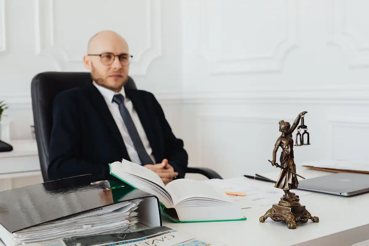 Avocat la birou, între dosare, cu o statuie a justiției alături