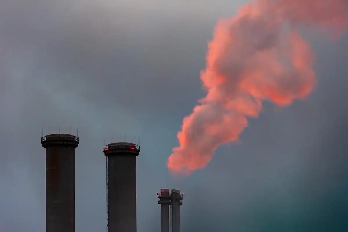 Coșuri industriale ale unei centrale termice, din care iese fum și abur