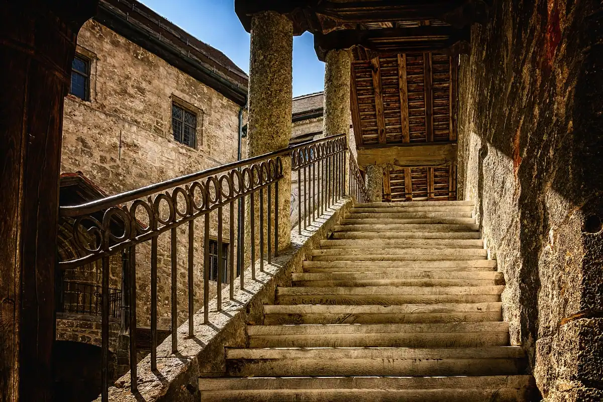 Scări de piatră cu balustradă care urcă într-o clădire veche, istorică