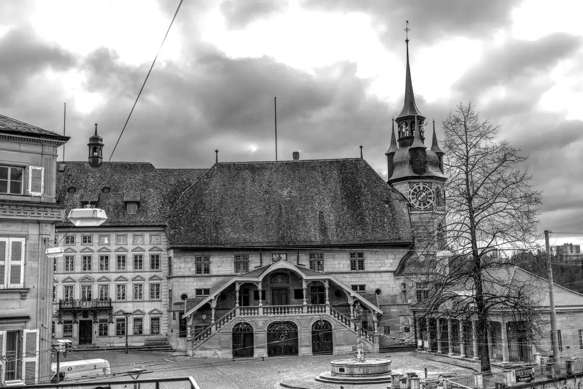 Clădire istorică cu turn cu ceas, fotografiată alb-negru