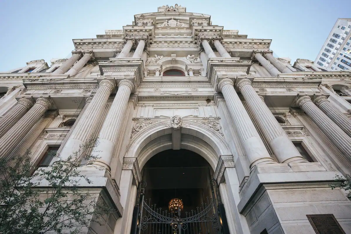 Fațada unei clădiri istorice monumentale, văzută de jos