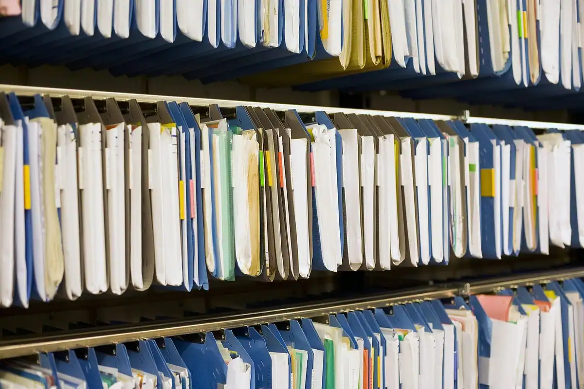Arhivă cu dosare și registre aranjate într-un birou, pentru păstrarea actelor