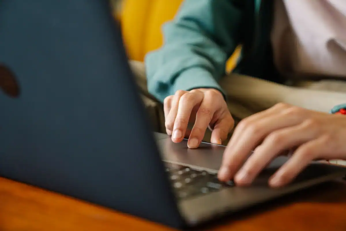 Mâini pe tastatura unui laptop, la o cerere depusă online