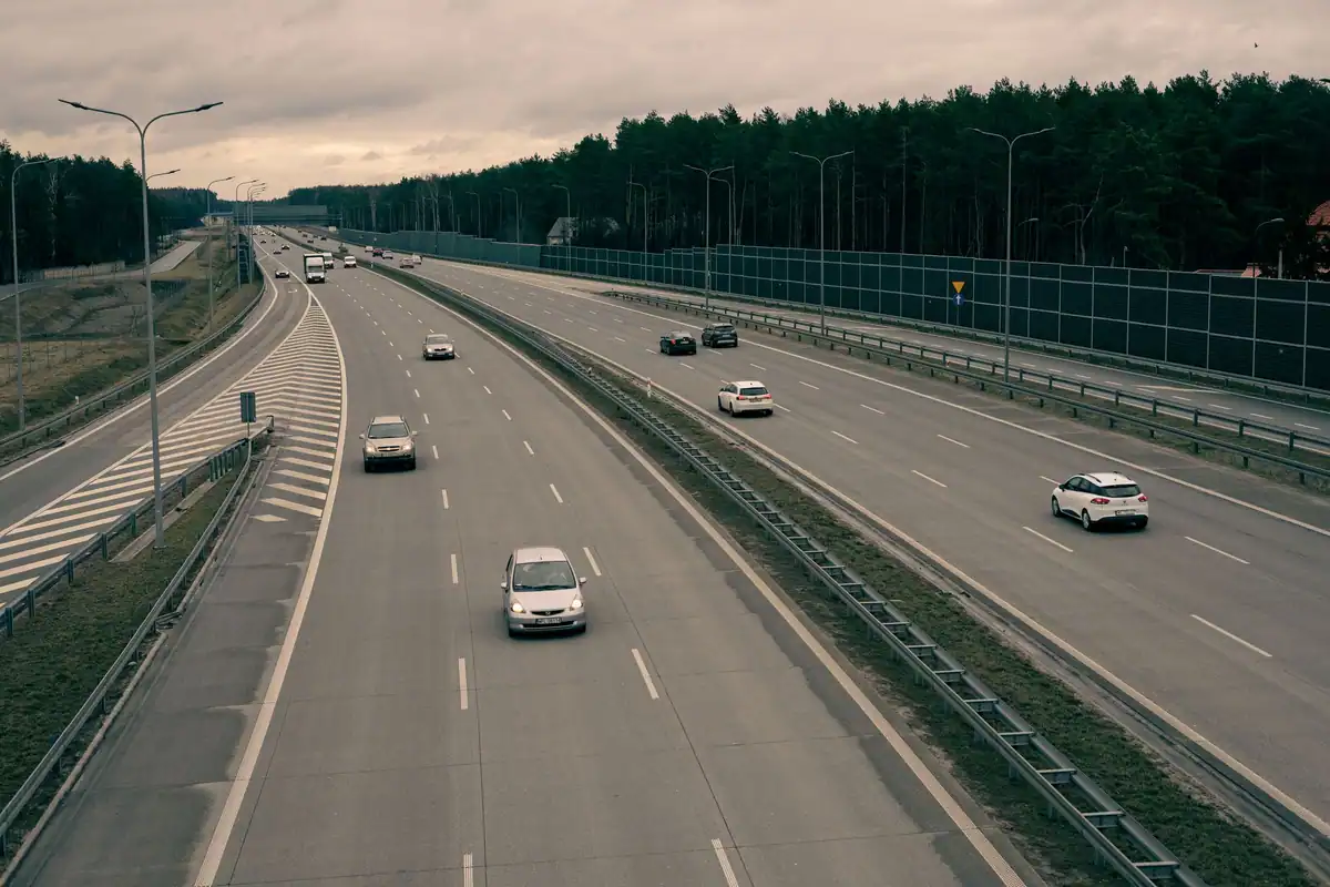 Autostradă cu mai multe benzi, străbătând o pădure deasă