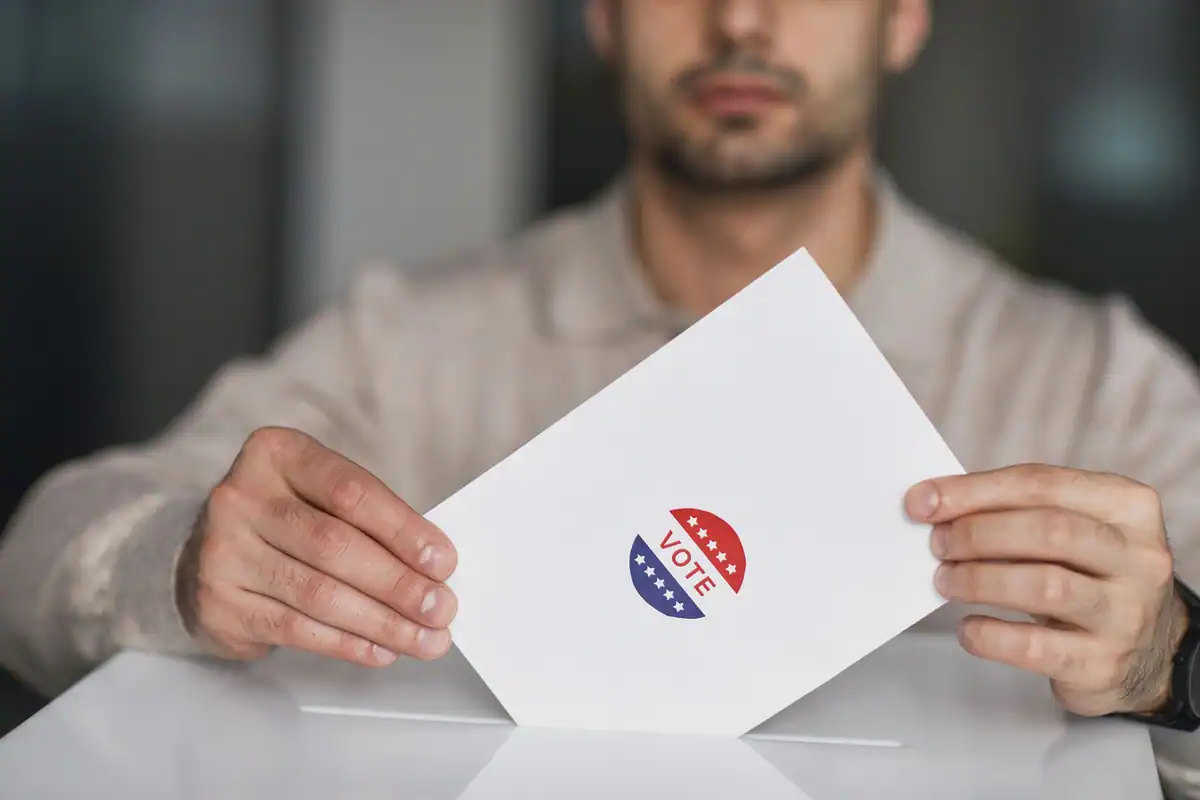 Bărbat care ține în mână un plic de vot cu un autocolant specific